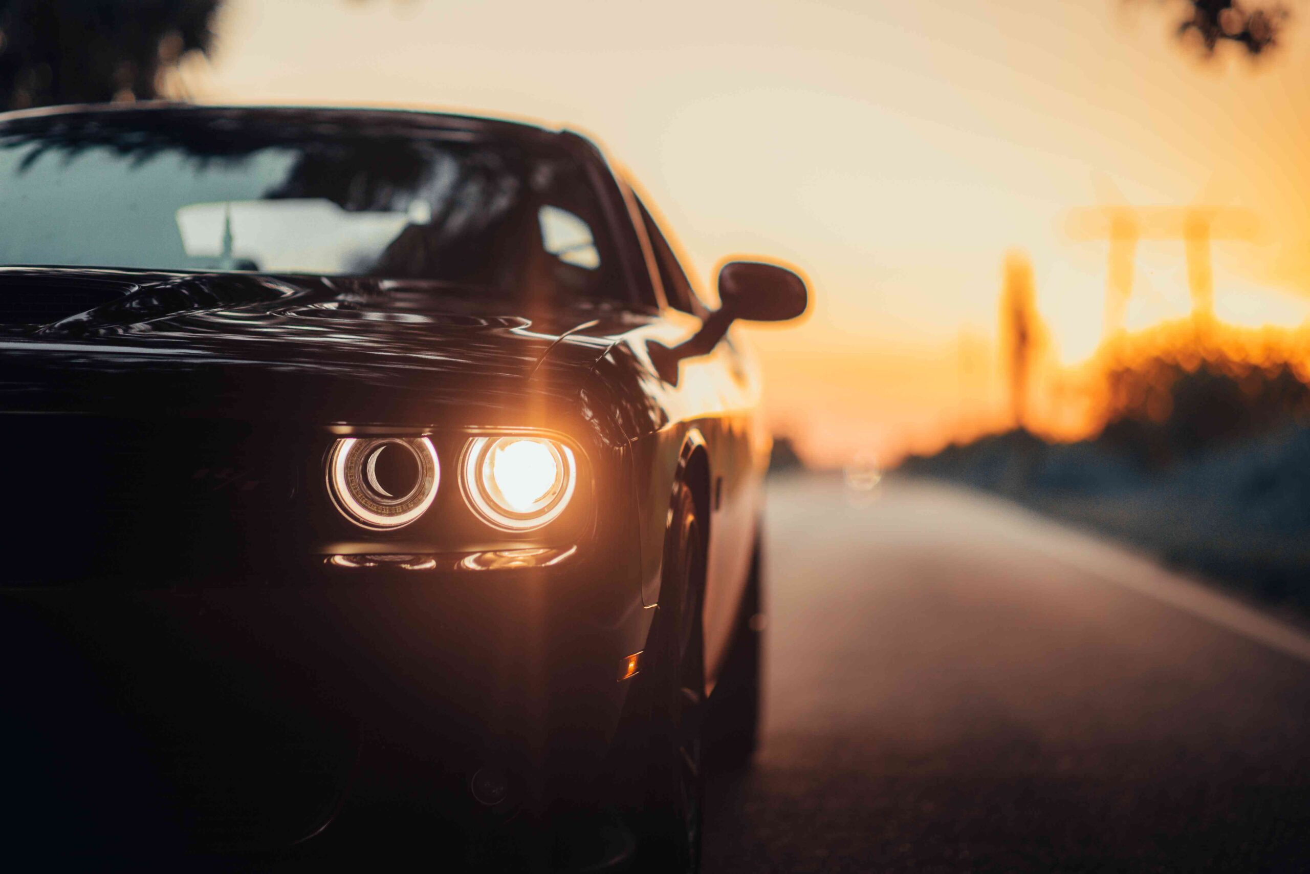 luxurious-car-parked-highway-with-illuminated-headlight-sunset_11zon